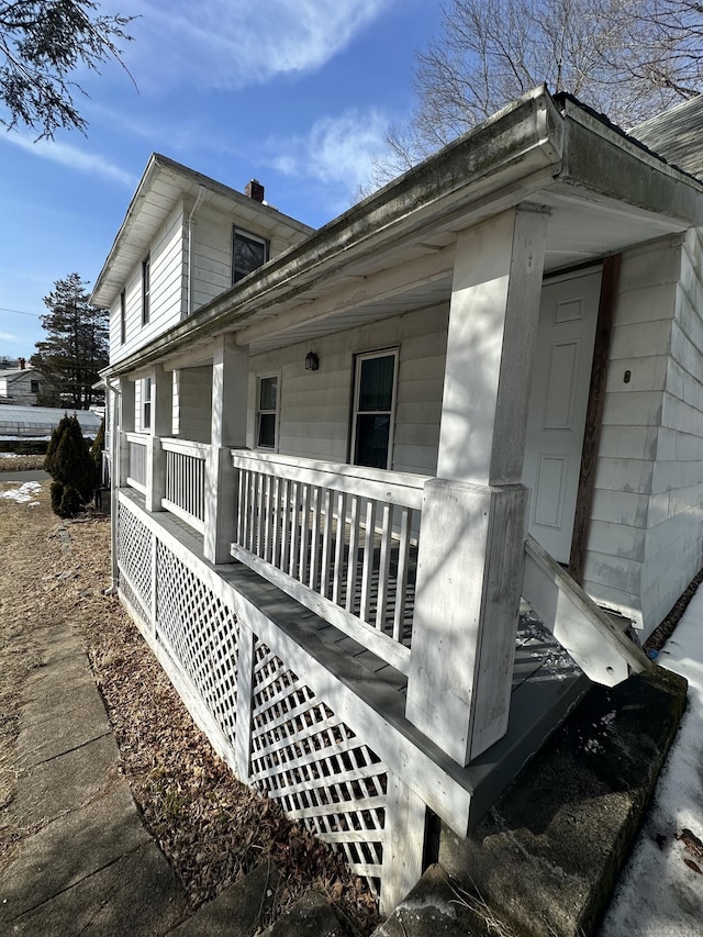 view of side of home featuring covered porch