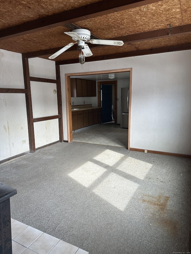 unfurnished room featuring light carpet, beamed ceiling, and ceiling fan