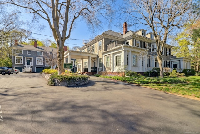 view of side of property with a chimney and a balcony