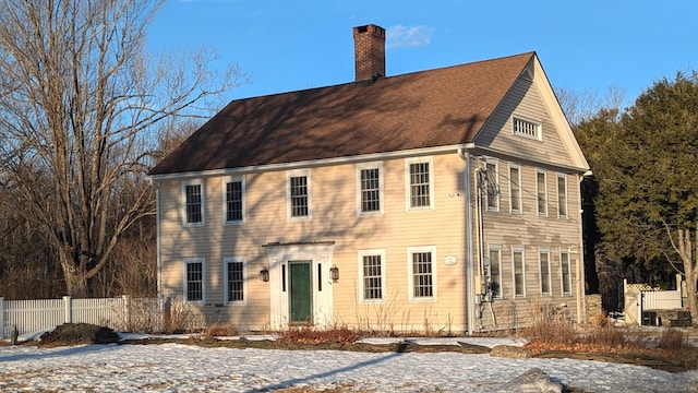 view of front of house featuring a chimney and fence