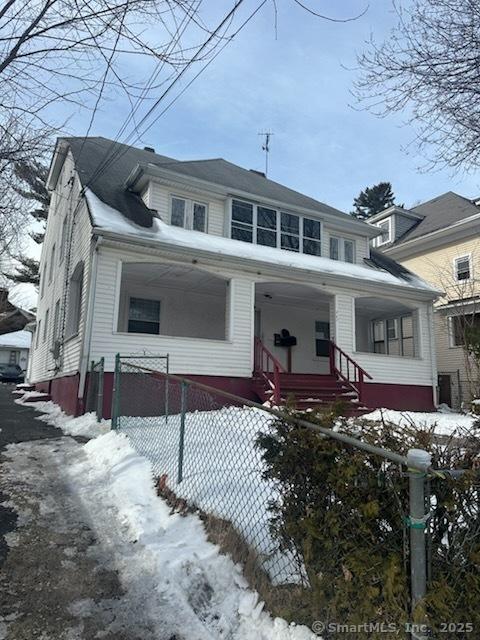 view of front facade featuring a porch and a fenced front yard