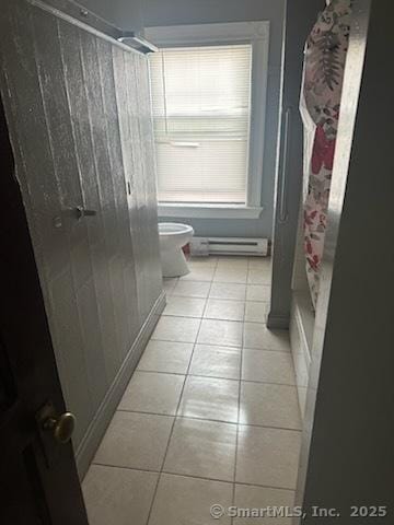 bathroom with a baseboard radiator, tile patterned flooring, and toilet