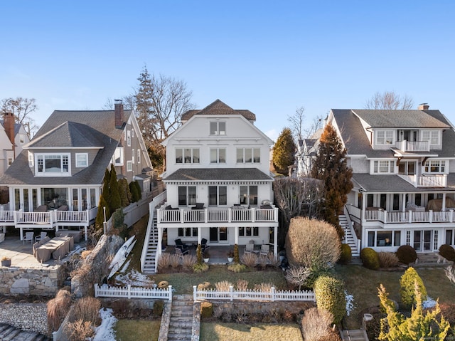 rear view of property featuring a fenced backyard, stairway, and a patio