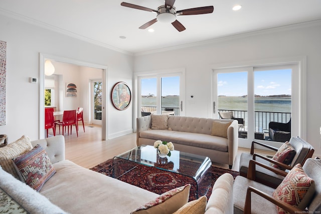 living area featuring recessed lighting, wood finished floors, a ceiling fan, baseboards, and crown molding