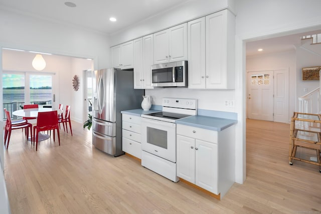 kitchen with stainless steel appliances, light wood-type flooring, and white cabinetry