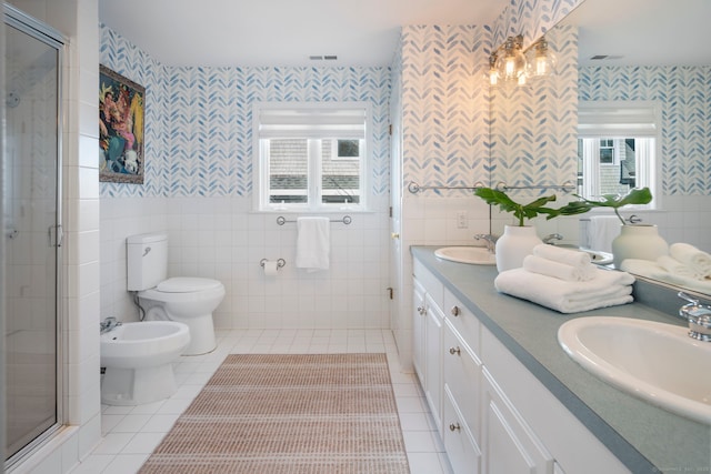 bathroom with a sink, tile walls, visible vents, a shower stall, and a bidet