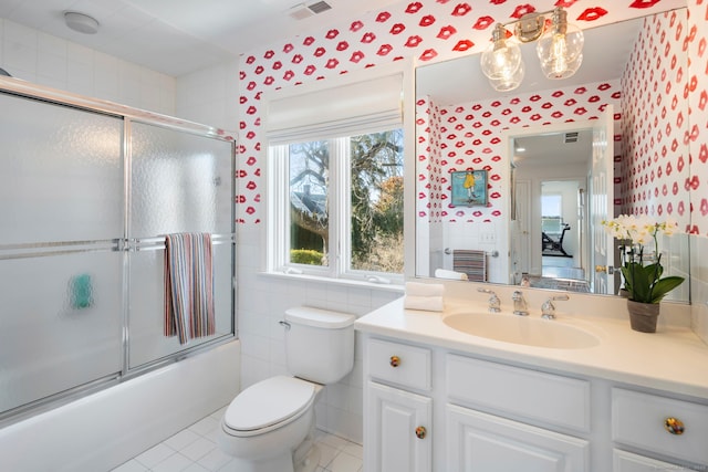 bathroom featuring bath / shower combo with glass door, visible vents, toilet, vanity, and wallpapered walls