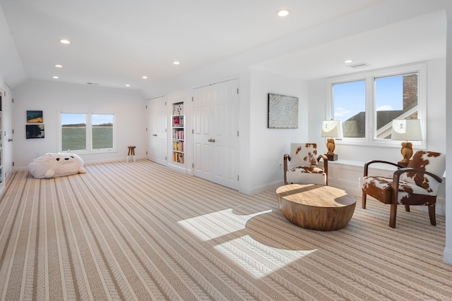 living area featuring lofted ceiling, recessed lighting, light colored carpet, visible vents, and baseboards