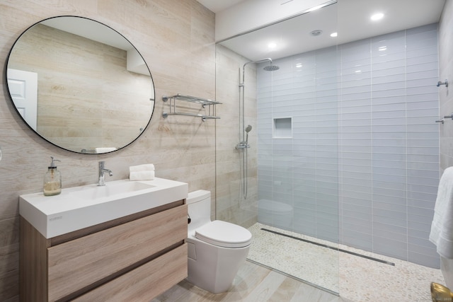 full bathroom with tile walls, vanity, toilet, and walk in shower