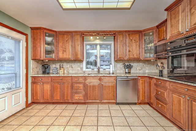 kitchen with glass insert cabinets, oven, dishwasher, and a sink