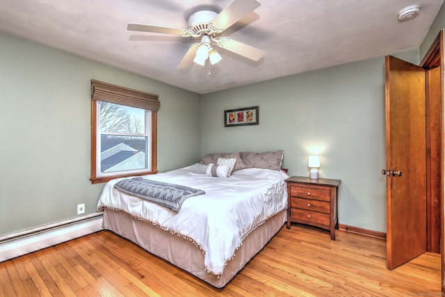 bedroom featuring light wood finished floors, baseboards, a baseboard heating unit, and ceiling fan