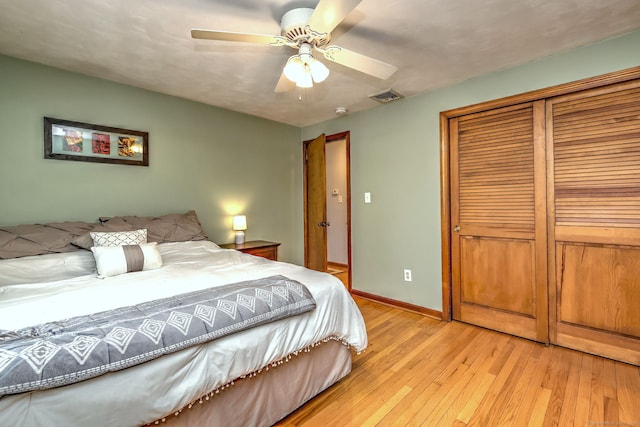 bedroom with visible vents, baseboards, a ceiling fan, light wood-style floors, and a closet