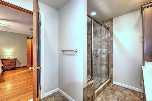 bathroom featuring a stall shower, baseboards, and vanity