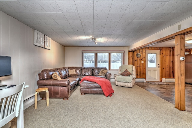 carpeted living room featuring a baseboard radiator, wood walls, and baseboard heating