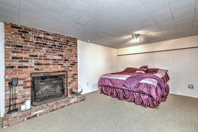 bedroom with a fireplace, track lighting, and carpet flooring