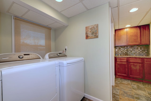 laundry room with baseboards, laundry area, washer and clothes dryer, and stone finish flooring