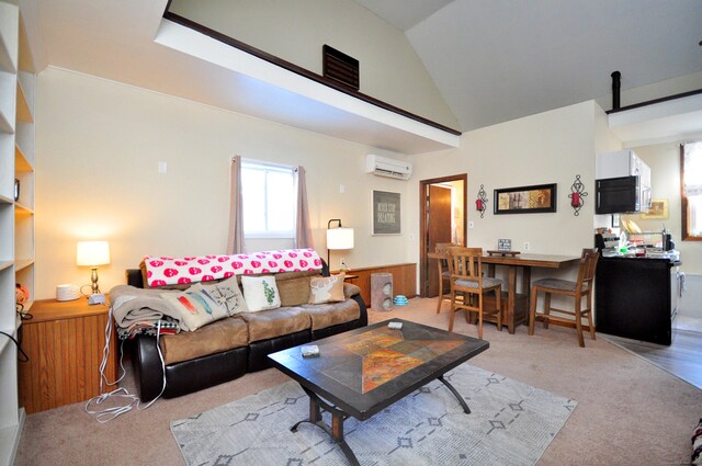 living area featuring high vaulted ceiling, light colored carpet, and a wall unit AC