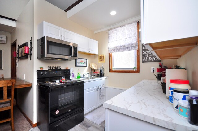 kitchen featuring black electric range, white cabinetry, stainless steel microwave, and a wall mounted AC