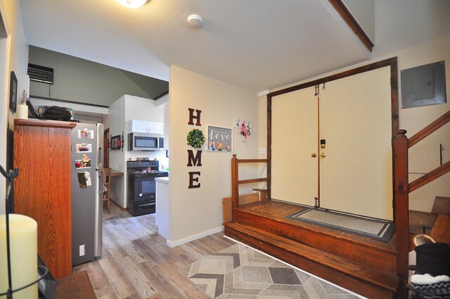 entryway featuring light wood-style floors, electric panel, and baseboards