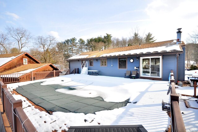 snow covered property with a deck