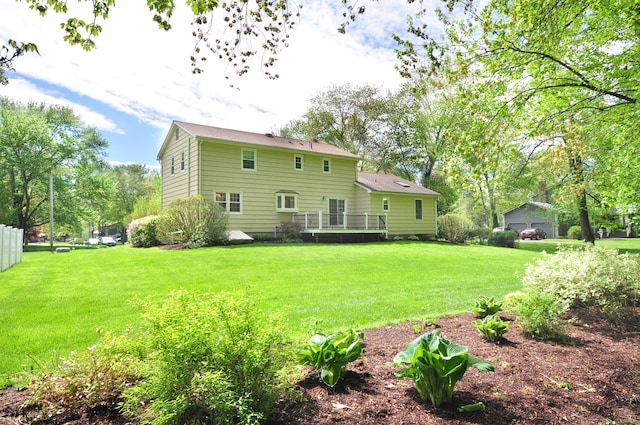 rear view of property with a deck and a yard