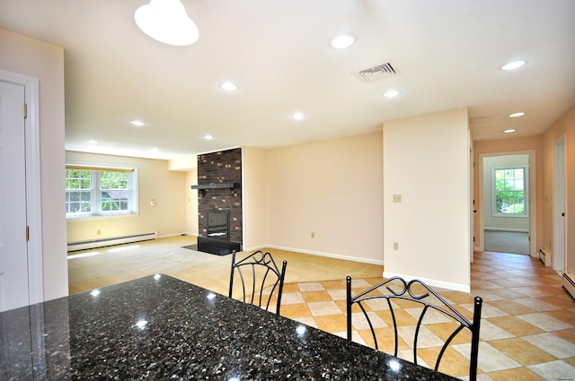 unfurnished dining area with a baseboard radiator, recessed lighting, a fireplace, and baseboards