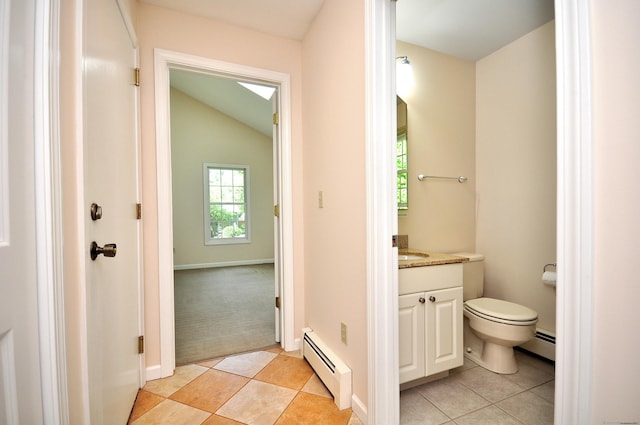 bathroom featuring baseboard heating, tile patterned flooring, vanity, toilet, and vaulted ceiling
