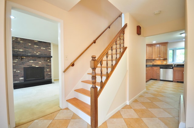 stairs featuring carpet, a brick fireplace, baseboards, tile patterned floors, and recessed lighting