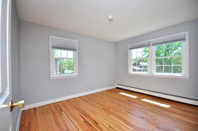 unfurnished room with healthy amount of natural light, light wood-type flooring, and baseboards
