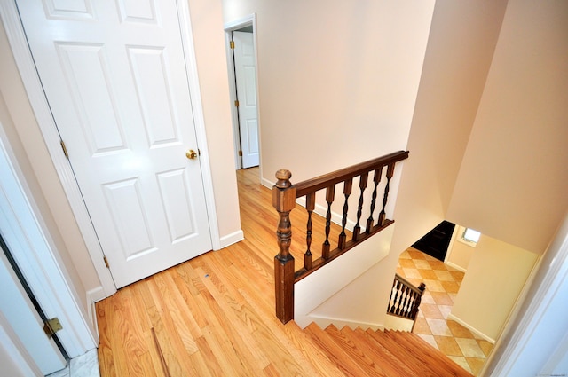 stairway with wood finished floors and baseboards