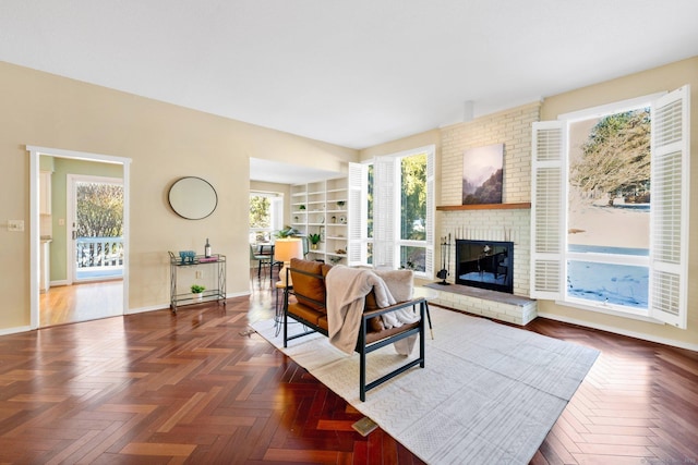 living room with baseboards, a brick fireplace, and a healthy amount of sunlight