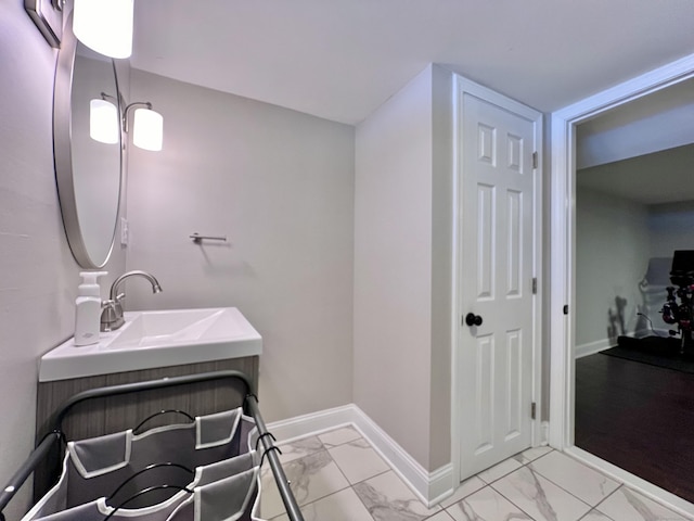 bathroom with marble finish floor, vanity, and baseboards