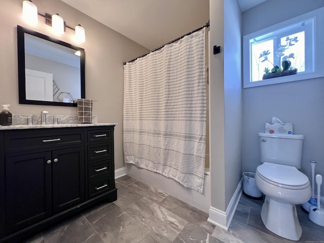 bathroom with shower / tub combo, baseboards, vanity, and toilet