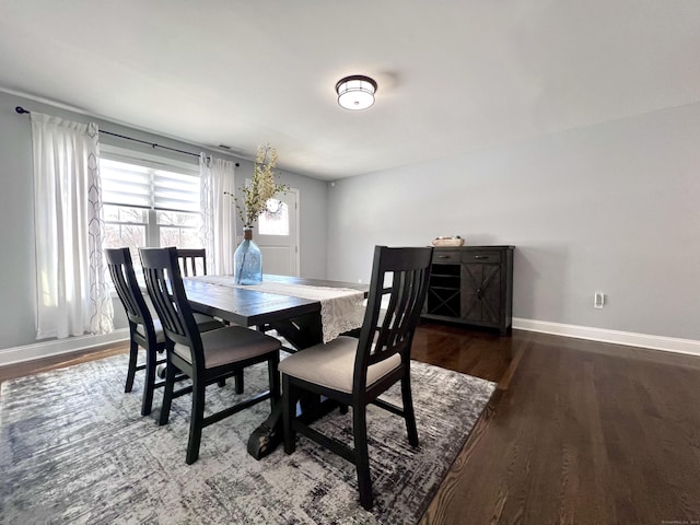 dining area with baseboards and wood finished floors