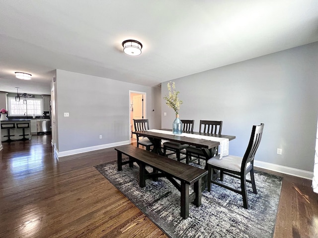 dining area featuring baseboards and dark wood finished floors