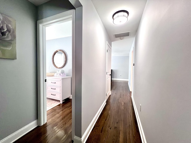 hall featuring visible vents, dark wood finished floors, and baseboards