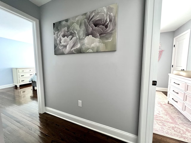 hall featuring baseboards and dark wood finished floors