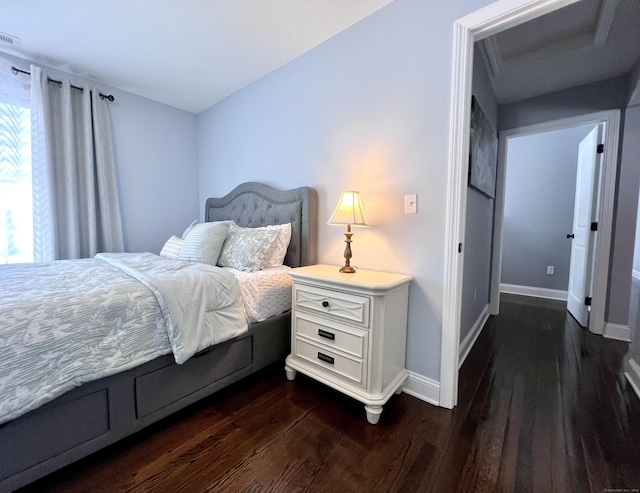 bedroom with dark wood-style flooring, visible vents, and baseboards