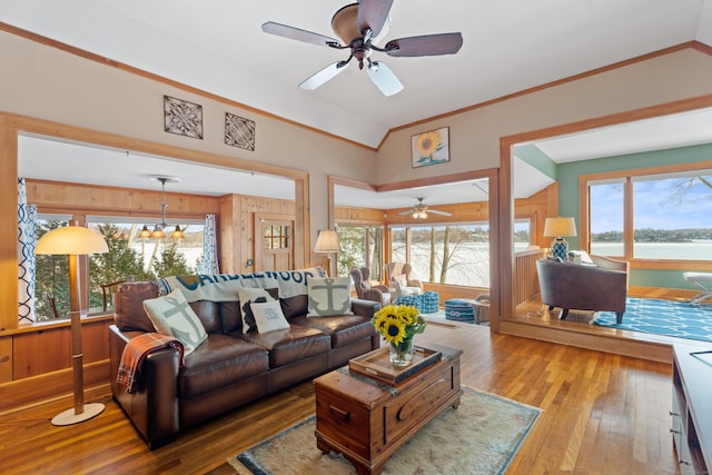 living room with a wealth of natural light, crown molding, hardwood / wood-style floors, and ceiling fan with notable chandelier