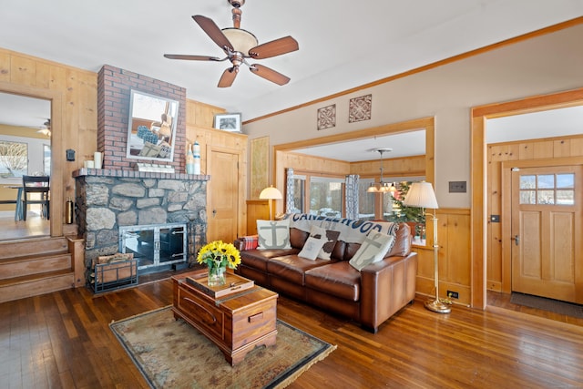 living room with plenty of natural light, wood-type flooring, a fireplace, and wooden walls