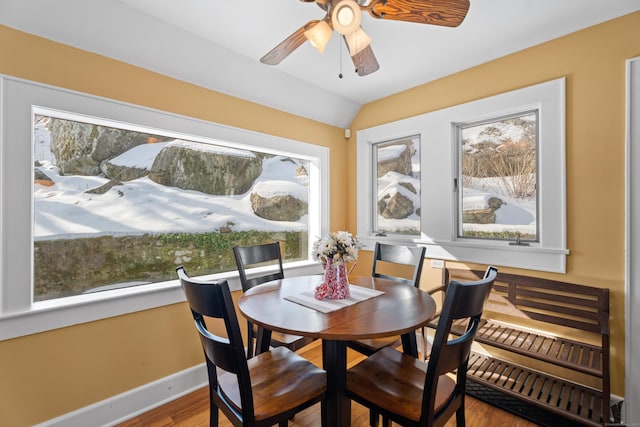 dining area featuring lofted ceiling, ceiling fan, wood finished floors, and baseboards