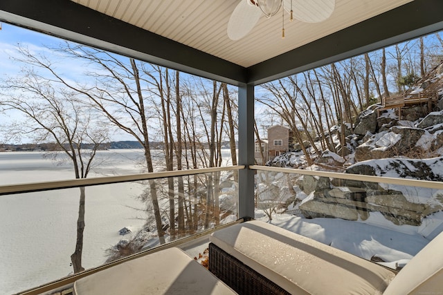 snow covered back of property featuring ceiling fan