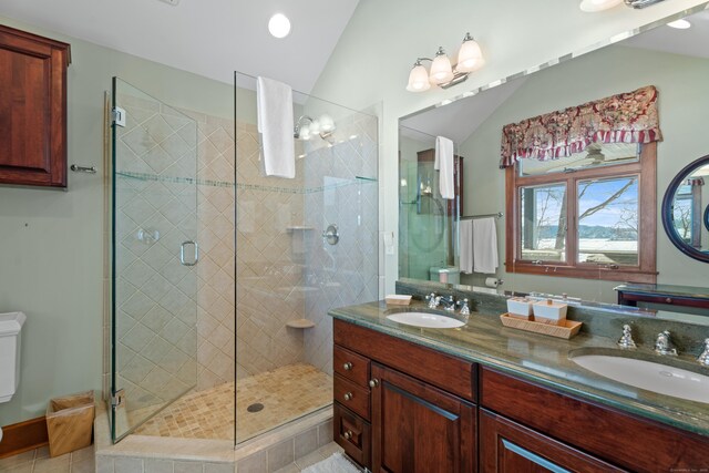 full bath with lofted ceiling, a shower stall, and a sink