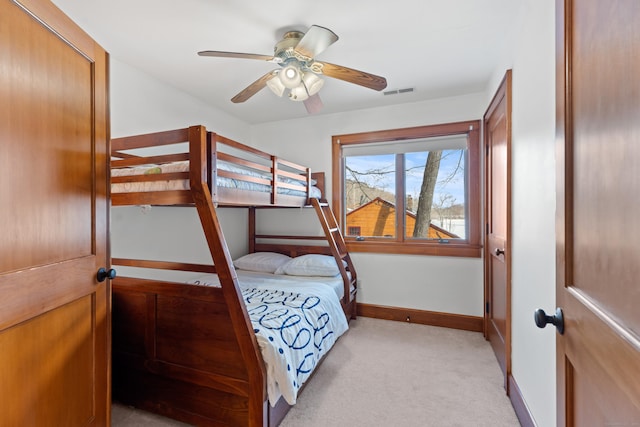 bedroom featuring light carpet, baseboards, visible vents, and a ceiling fan