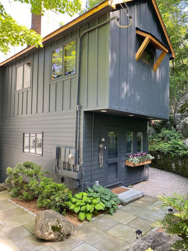 back of property featuring board and batten siding and a chimney