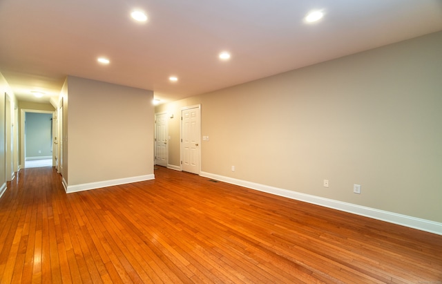 unfurnished room featuring baseboards, hardwood / wood-style floors, and recessed lighting