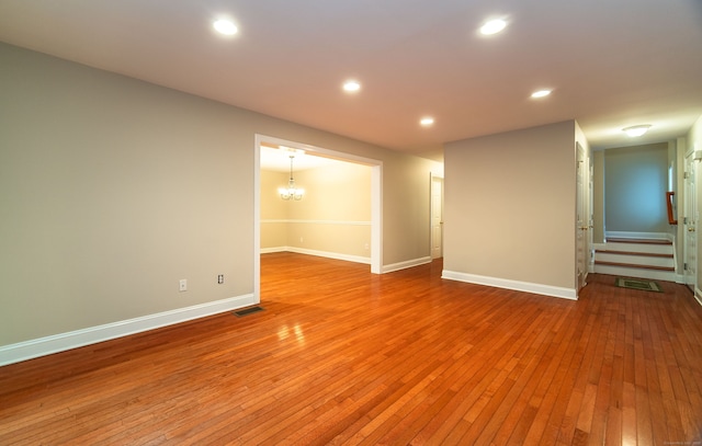 unfurnished room with recessed lighting, visible vents, light wood-type flooring, baseboards, and stairs