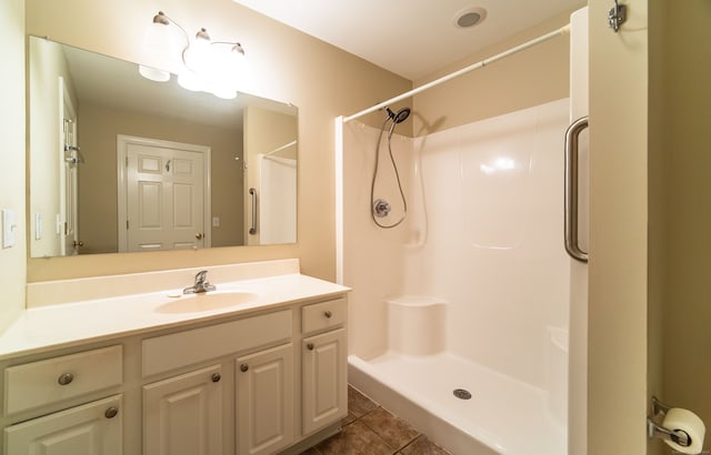 bathroom featuring tile patterned flooring, a shower, and vanity