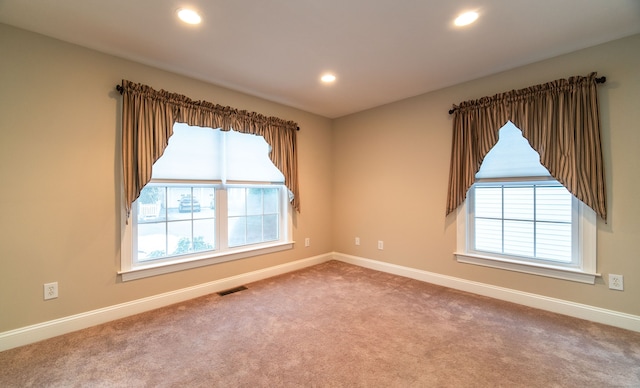 carpeted empty room with baseboards, plenty of natural light, visible vents, and recessed lighting