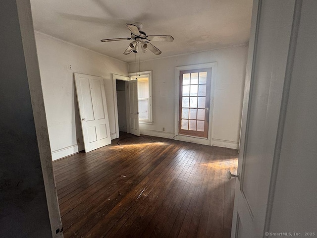 unfurnished bedroom with dark wood-style floors, ceiling fan, and baseboards